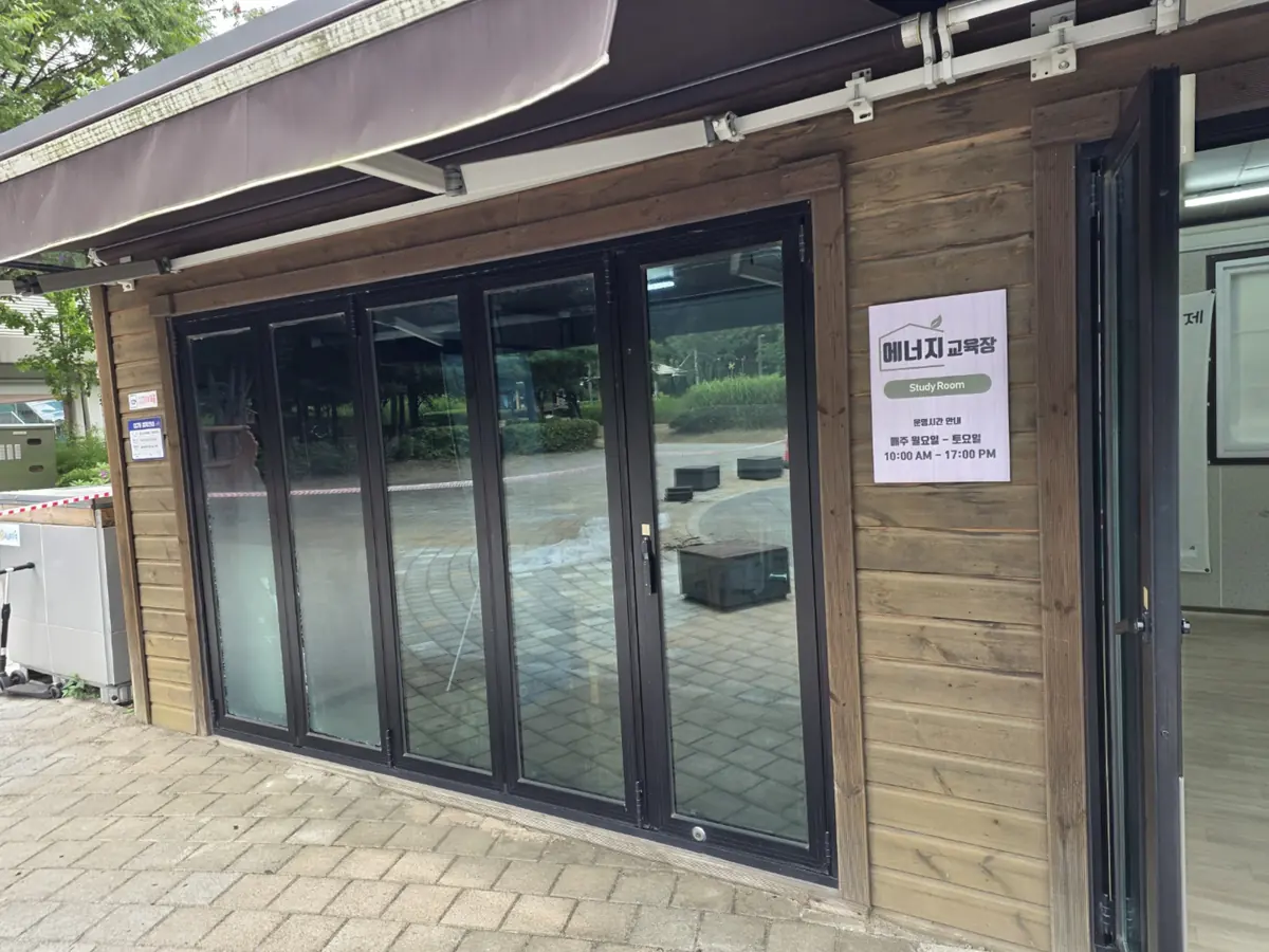 목재 외벽 건물에 설치된 블랙 프레임 접이식 문